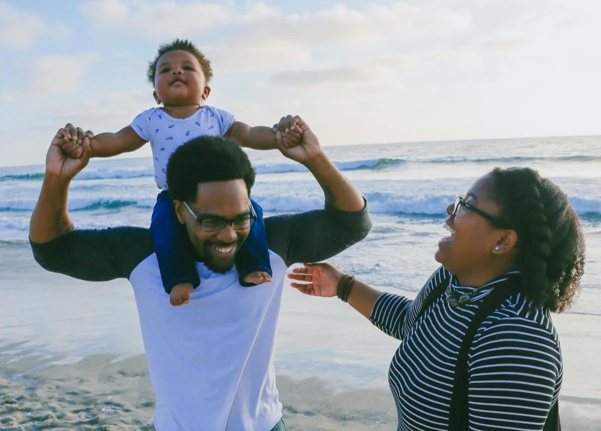 Happy family enjoying a day at the beach after gaining financial freedom